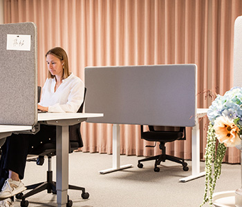 Kvinna sitter i ett skrivbordslandskap